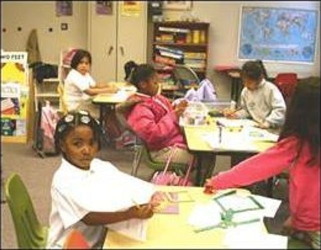 Students working at yellow tables in a classroom