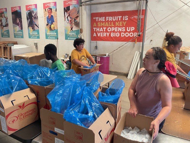 Pablo helping pack food bags with a group during a mission trip service project.