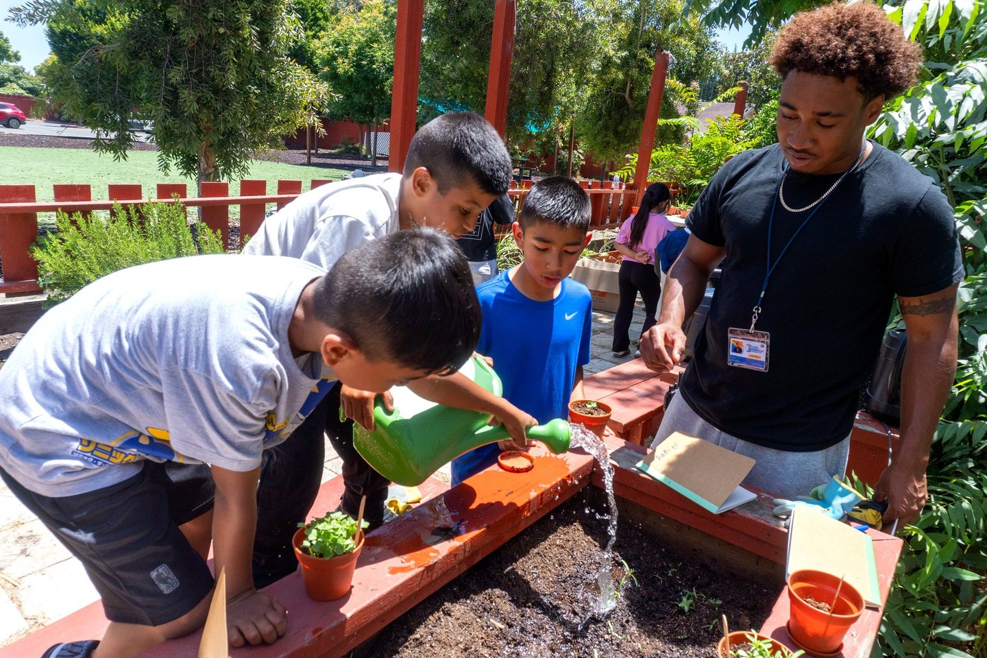 Hope Horizon campers watering a garden bed with a staff mentor