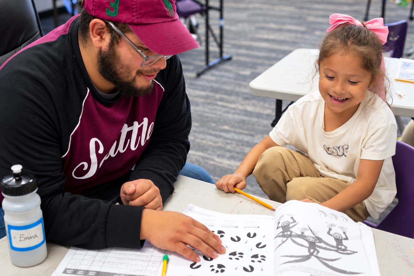 A tutor helping a young student with a drawing worksheet