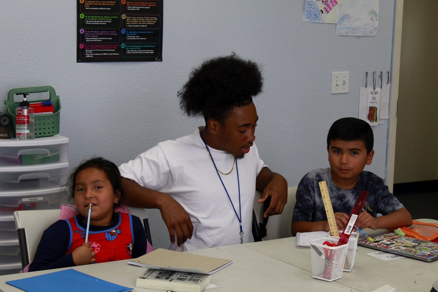 A tutor working with two Hope Horizon students