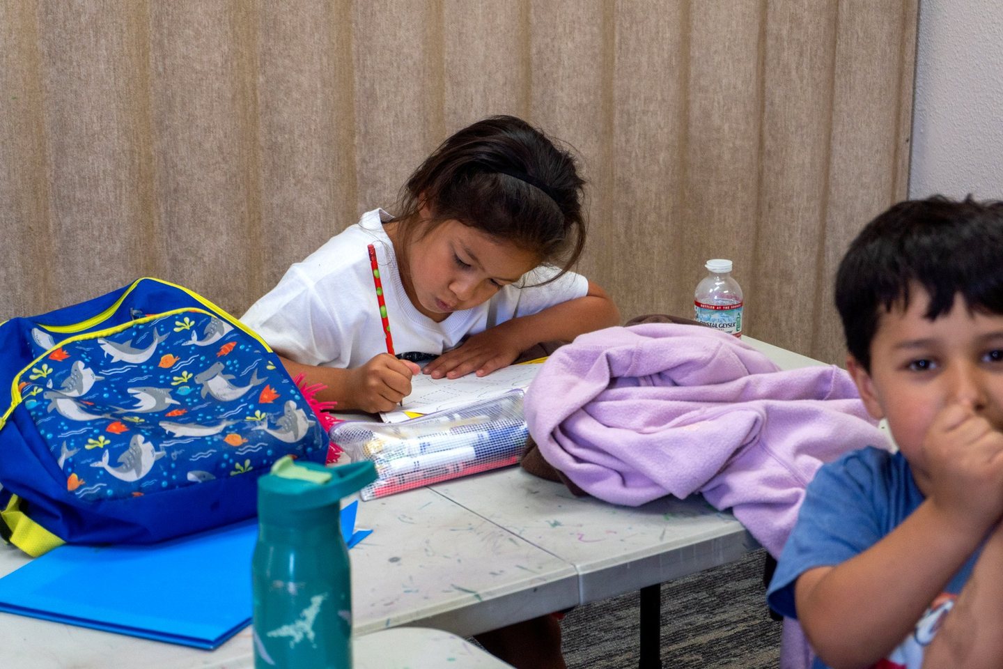 A Hope Horizon student writing at the afterschool table