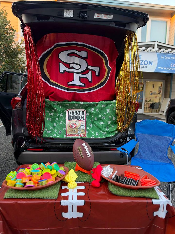 A trunk decorated as a 49ers locker room, with a team flag, a football and bowls of treats on a table