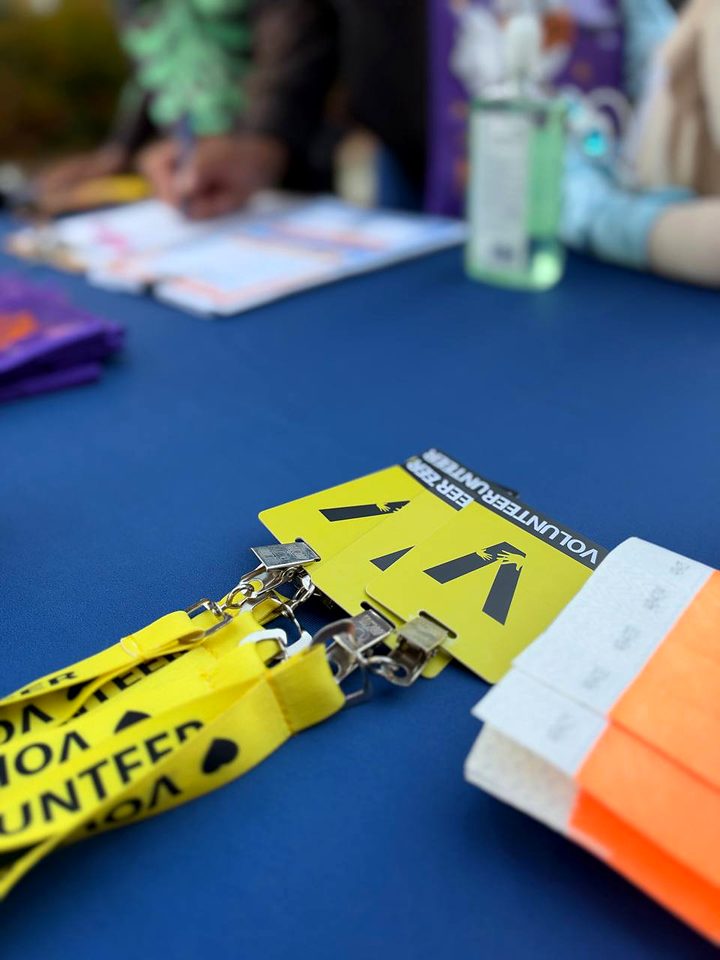 Yellow volunteer lanyards on the blue checkin table