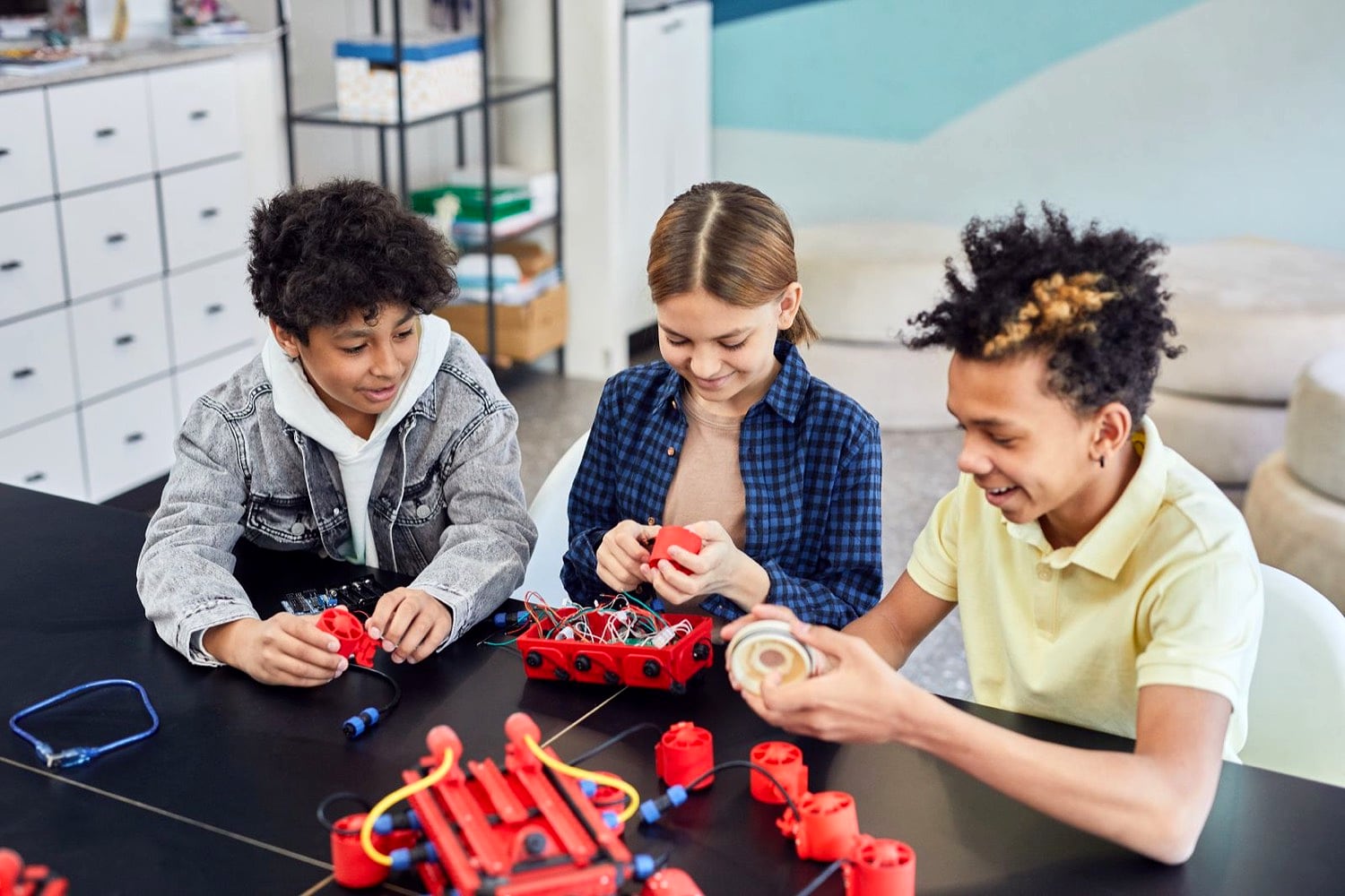 Three Hope Horizon students building robots side by side