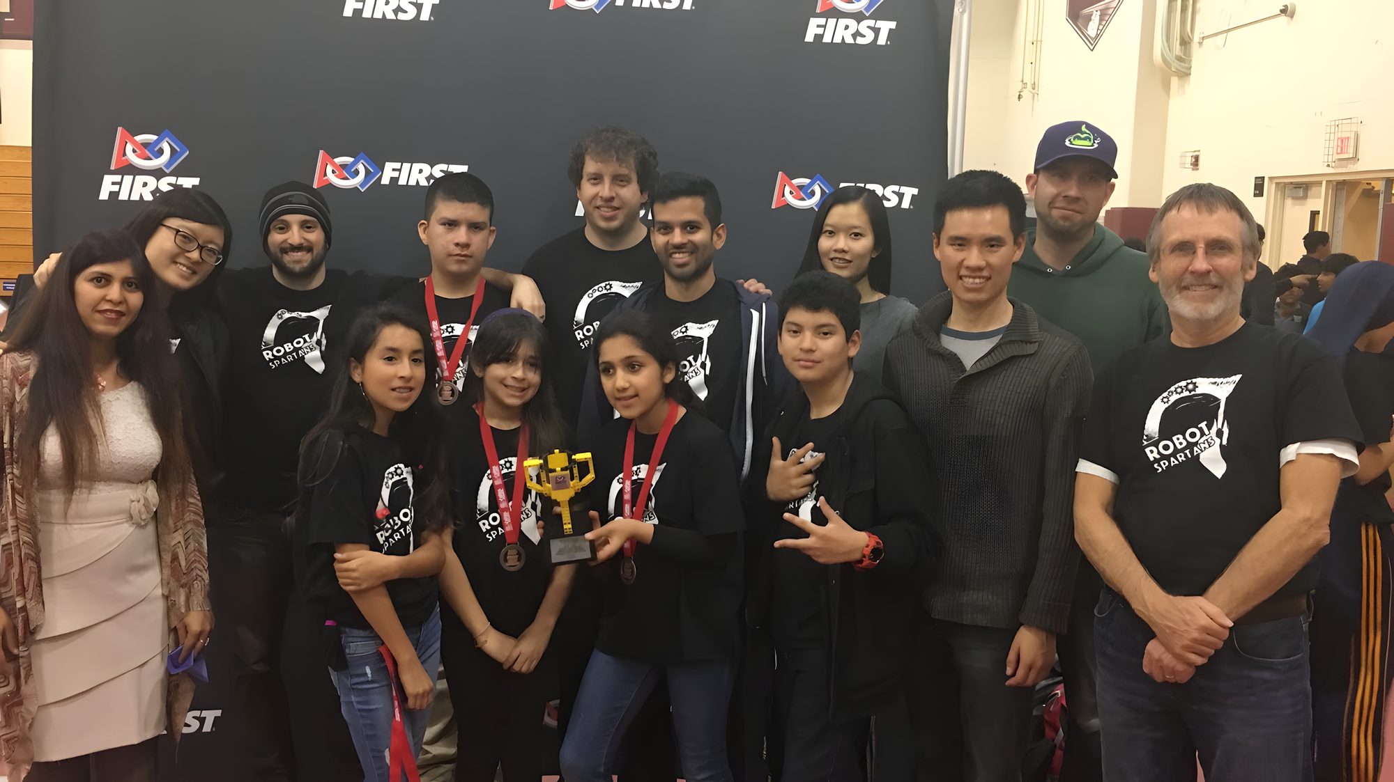 The early ChurroBots team and mentors at a FIRST event, several students holding medals
